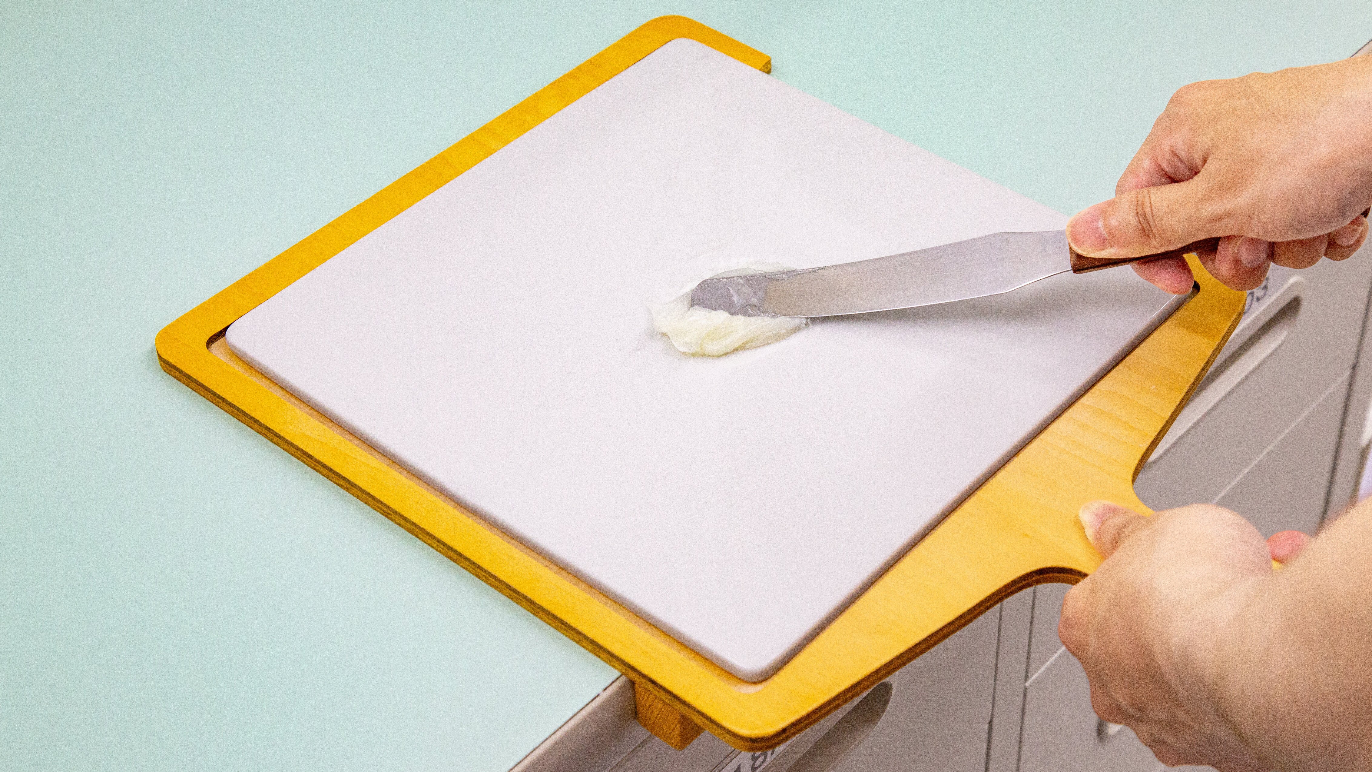 ヘラと軟膏板を使って軟膏を練る様子の写真。