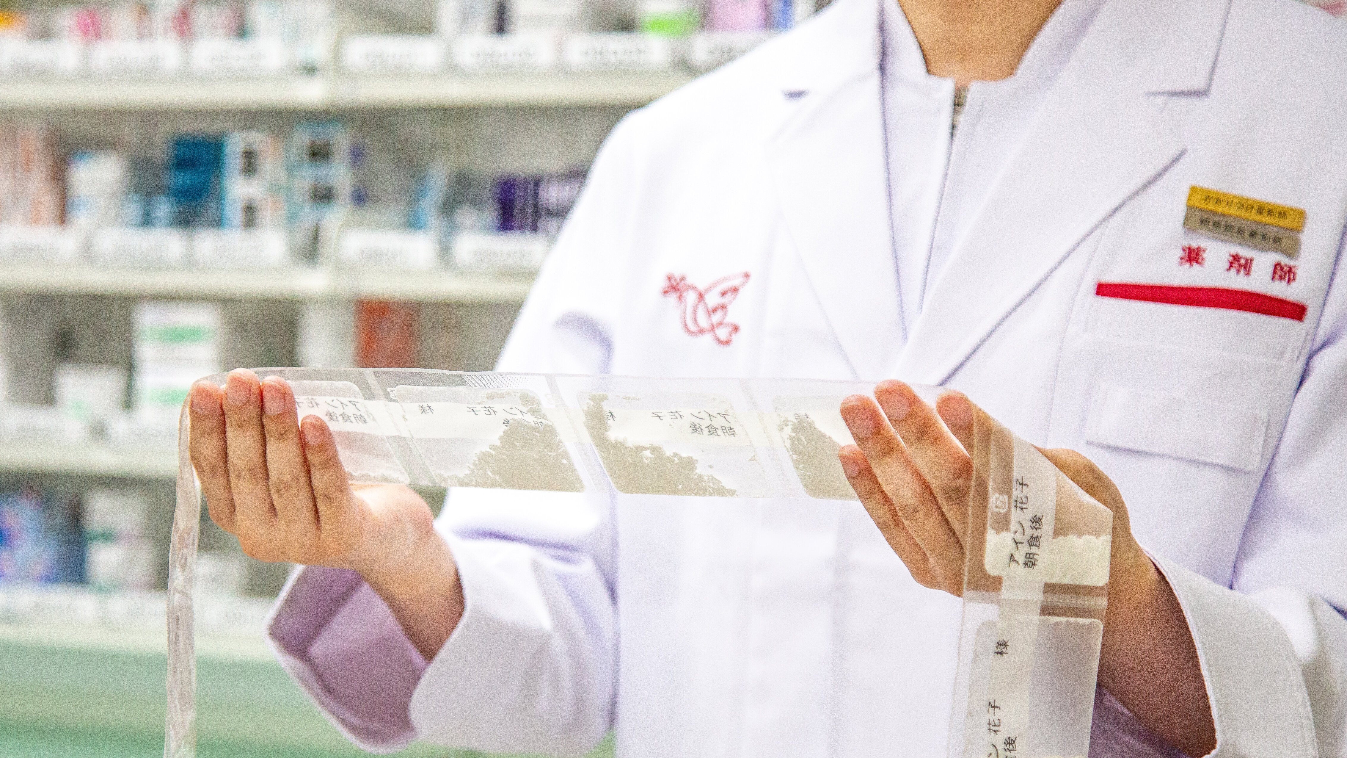 薬剤師が分包化された薬を手に持ちチェックしている様子の写真。