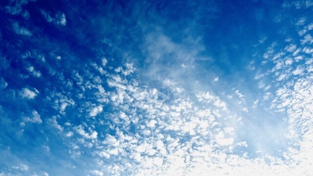 深い青の美しい空とそこに浮かぶ羊雲のイメージ画像