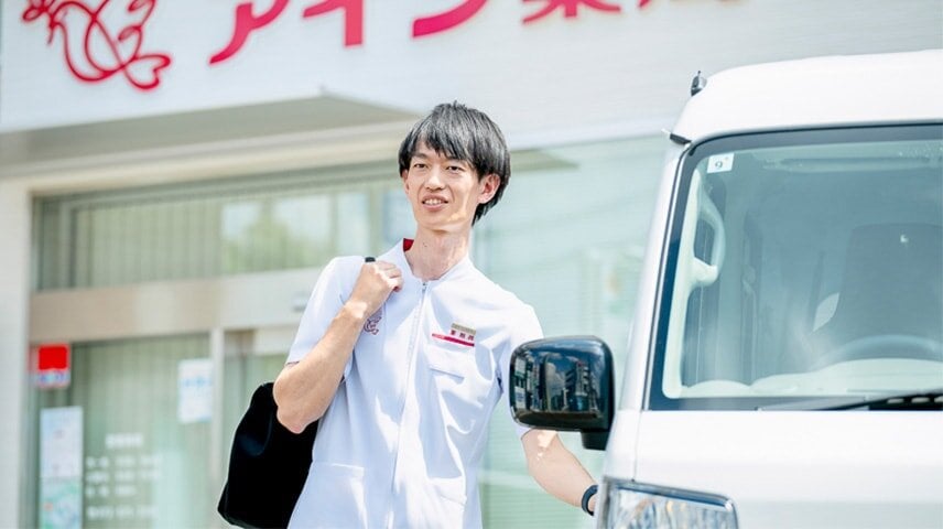 車のドアに手をかけ笑顔を浮かべる松村さん