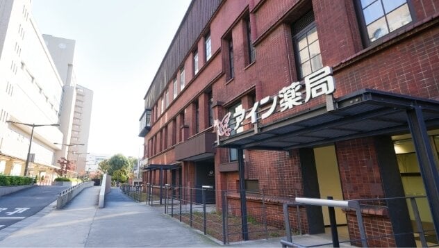 レンガ造り風の建物のアイン薬局 東大店（東京都）。左手にはスロープが見える。